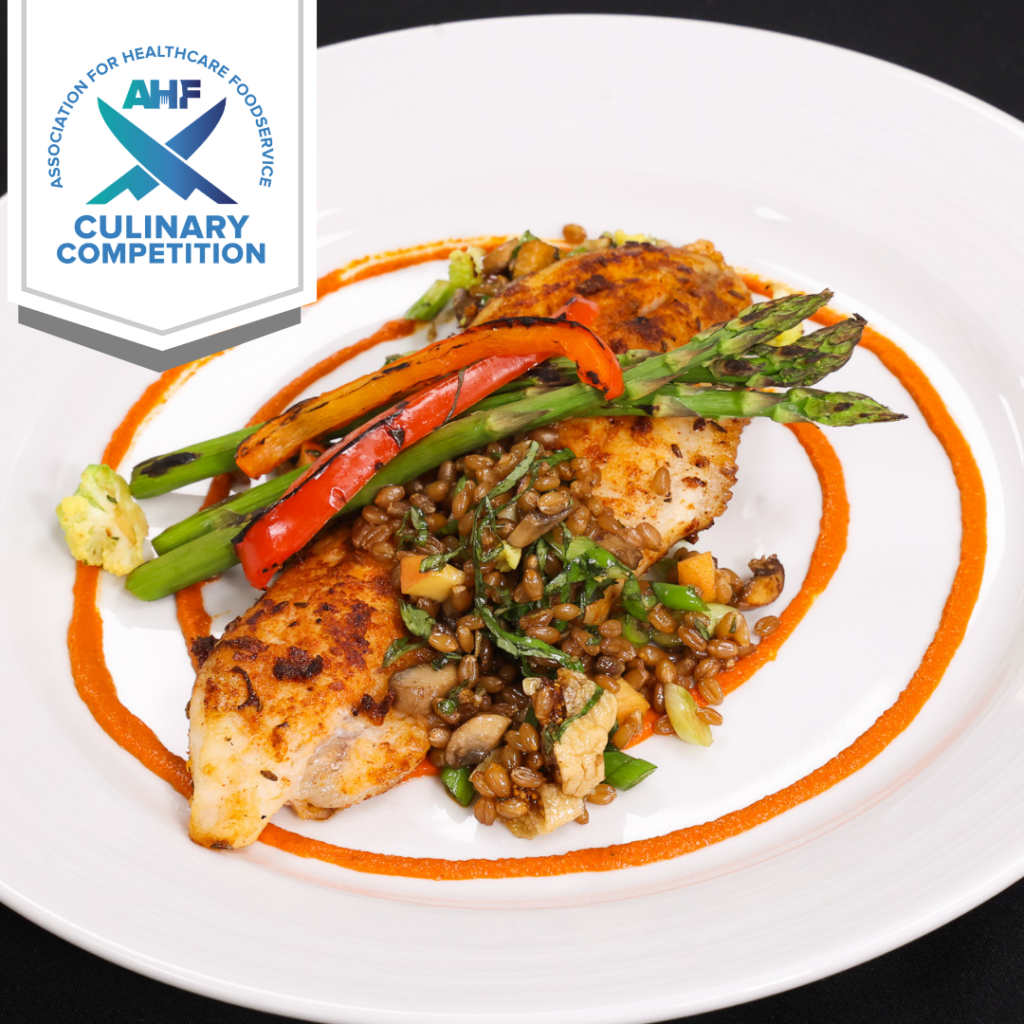 cat fish filet atop wheatberry salad and topped with asparagus and red bell pepper strips.